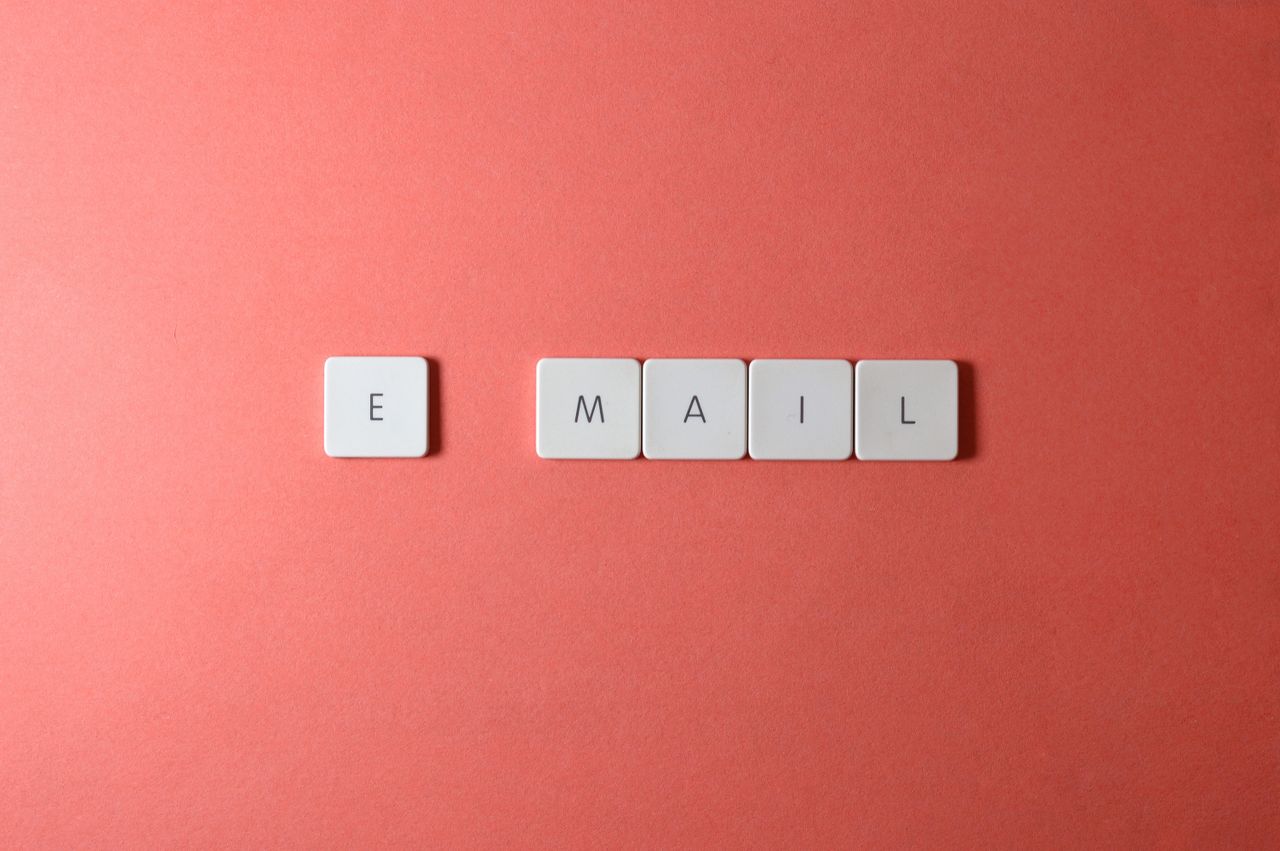 services-02 Flat-lay composition of keyboard letter tiles spelling email against a coral background.